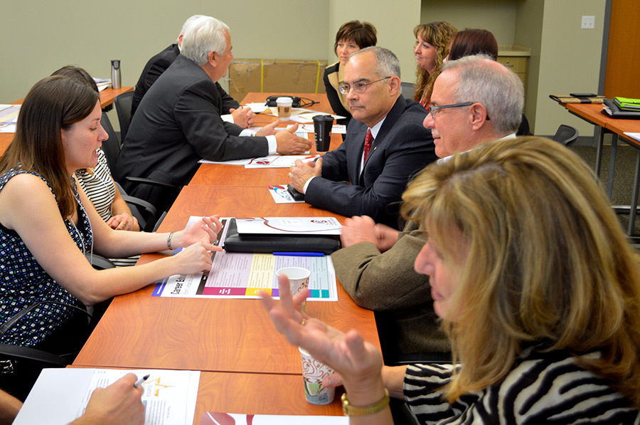 business leaders and educators working at a series of tables