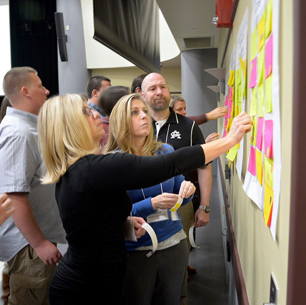 People using sticky notes on a wall to plan and brainstorm